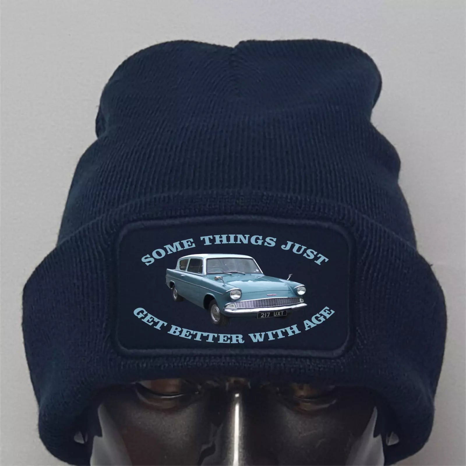 Navy blue beanie with a patch featuring a car and text on a gray background