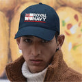 Person wearing a navy 'Royal Navy' cap with a blurred background