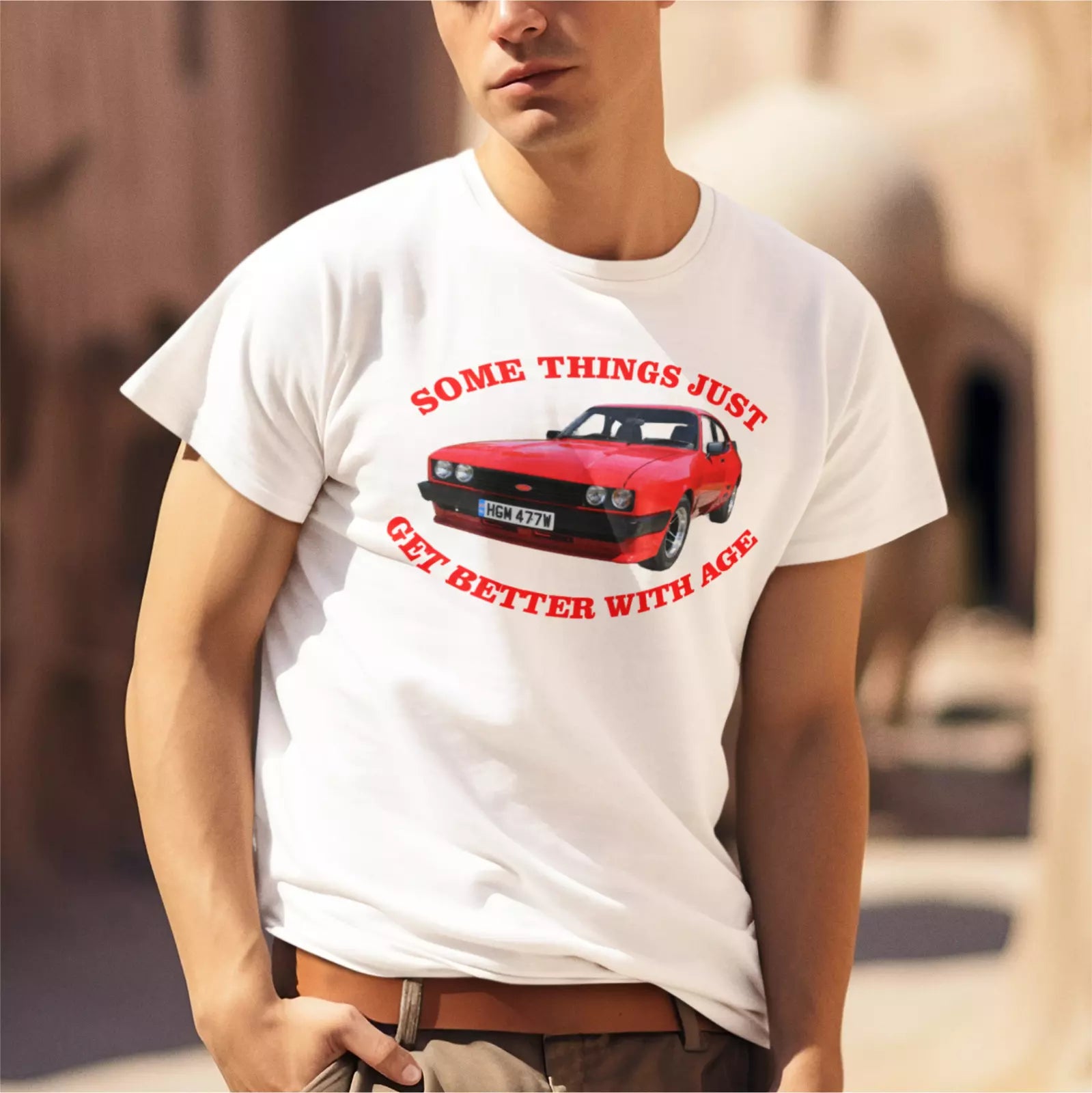 Person wearing a white t-shirt with a red car graphic and text.